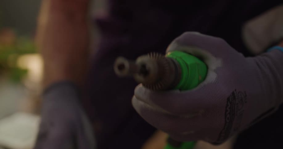 Pair of gloved hands handling a screwdriver