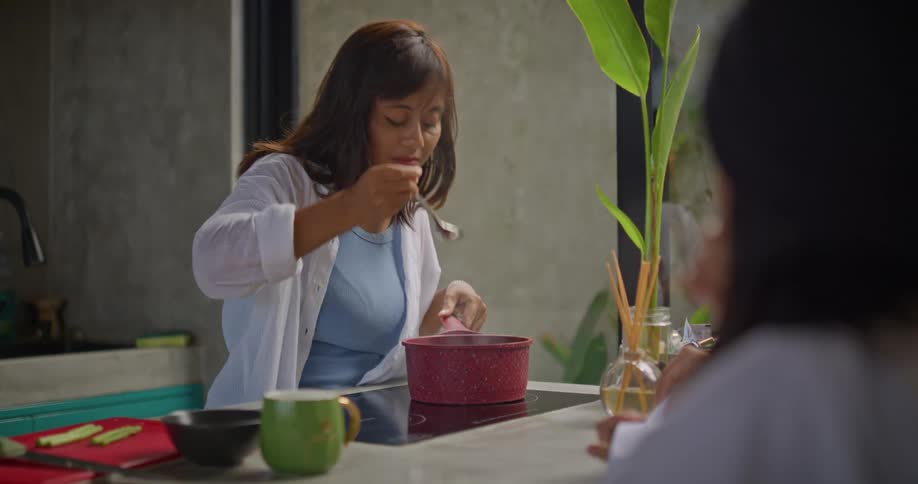 A mom is cooking while talking with her kids