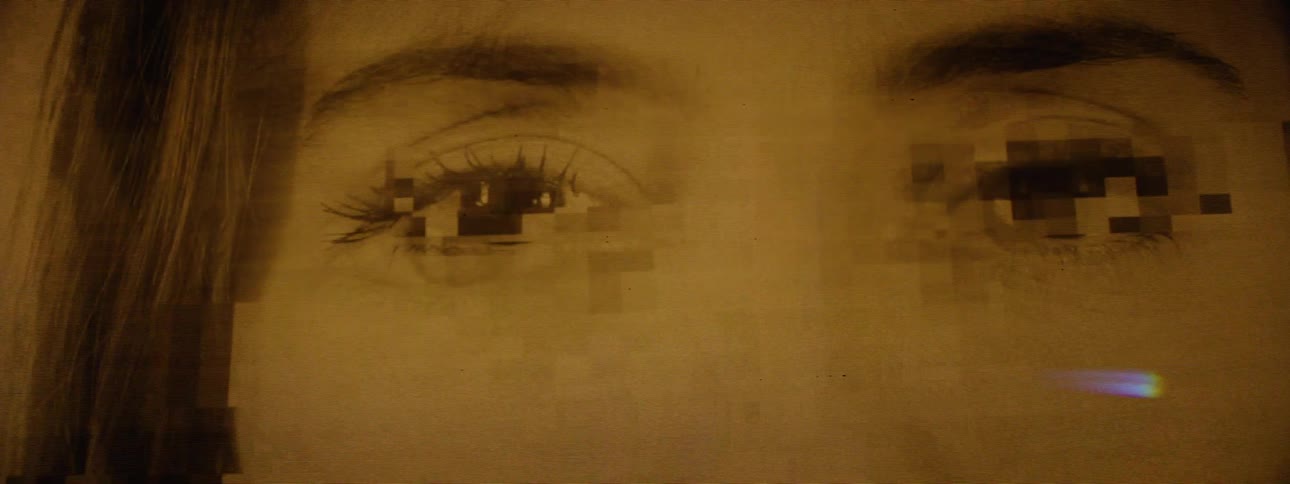 Closeup of a screen showing rapidly transitioning pixelated images of mens and womens eyes