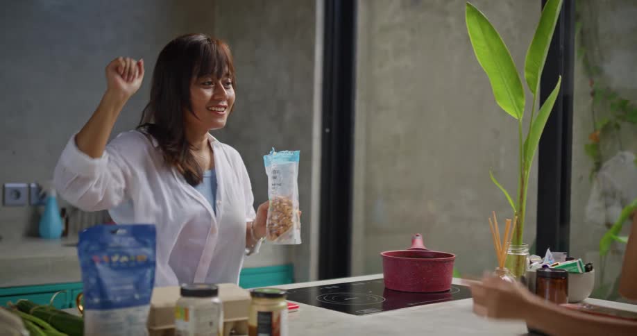 Mother giving her daughter a high five while holding a bag of granola
