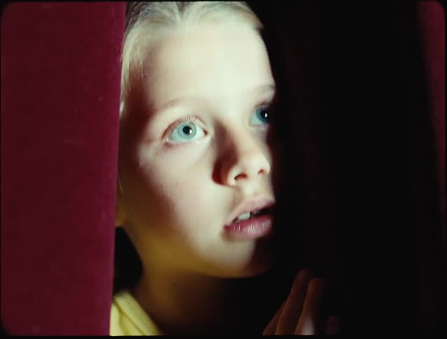 Closeup of a girls face in the dark under flickering lights