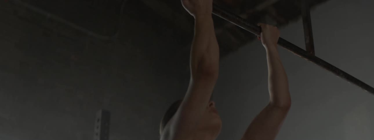 A woman exercises on a pull up bar