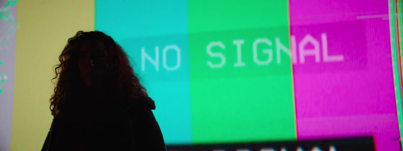 Woman with curly hair standing in front of a large projector screen