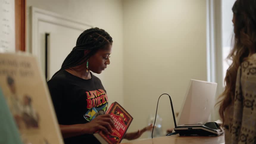 A footage of a person renting a book at the library