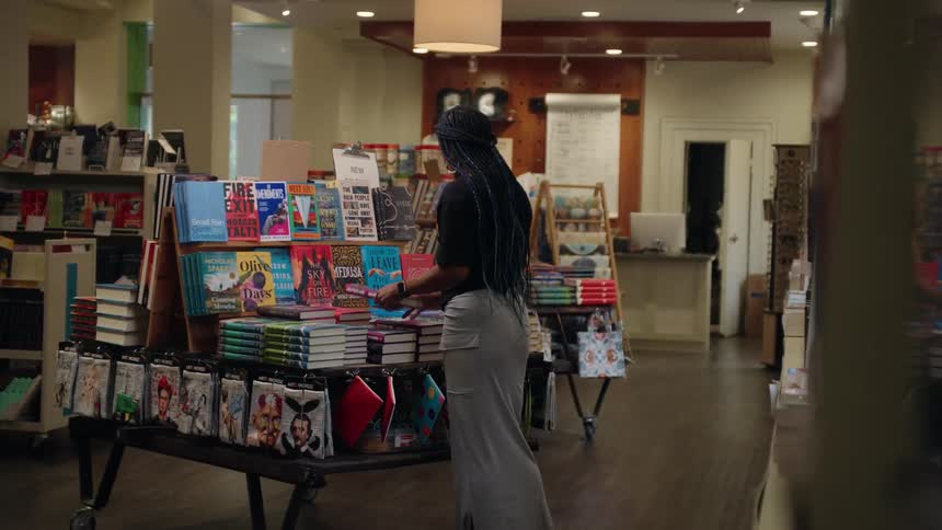 A woman stacks books on the display in the bookstore