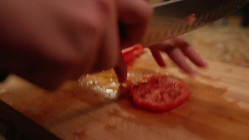 Pair of hands cutting tomato