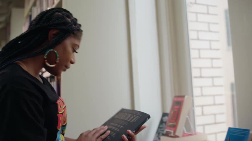 A woman picks up a book and flips through it in the book store