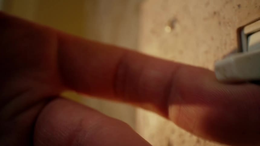 A person flips the switch outside