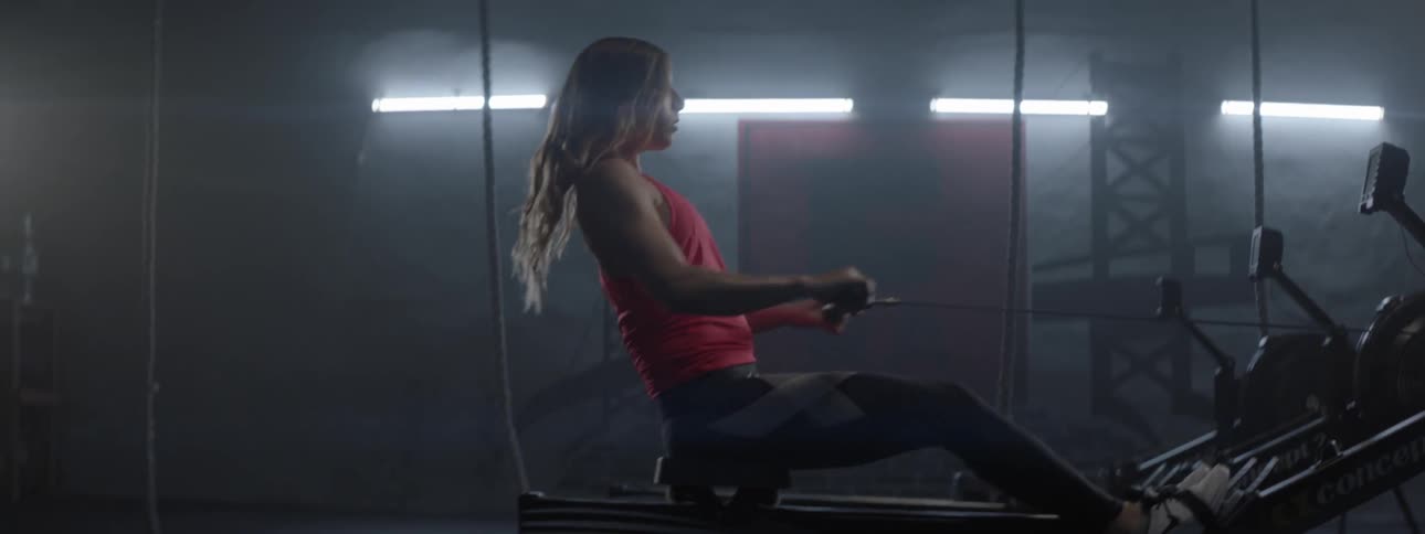 A woman is exercising on a machine in a gym