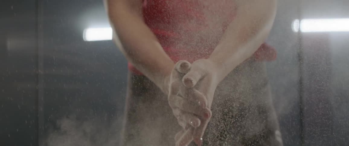 Athlete dips hands in chalk and rubs them together