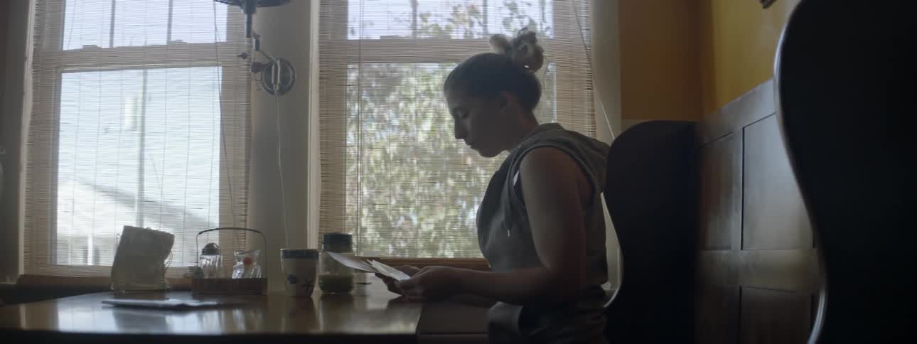 A woman sitting at a table looking through pictures