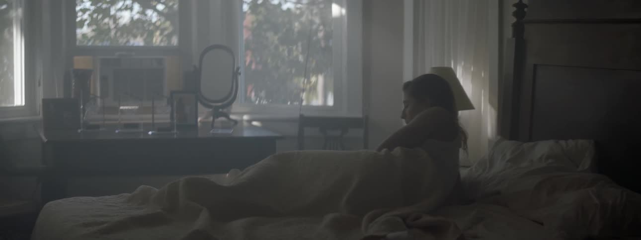 A woman wakes up in bed