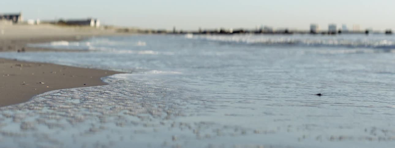 A close up view of a beach with water incoming