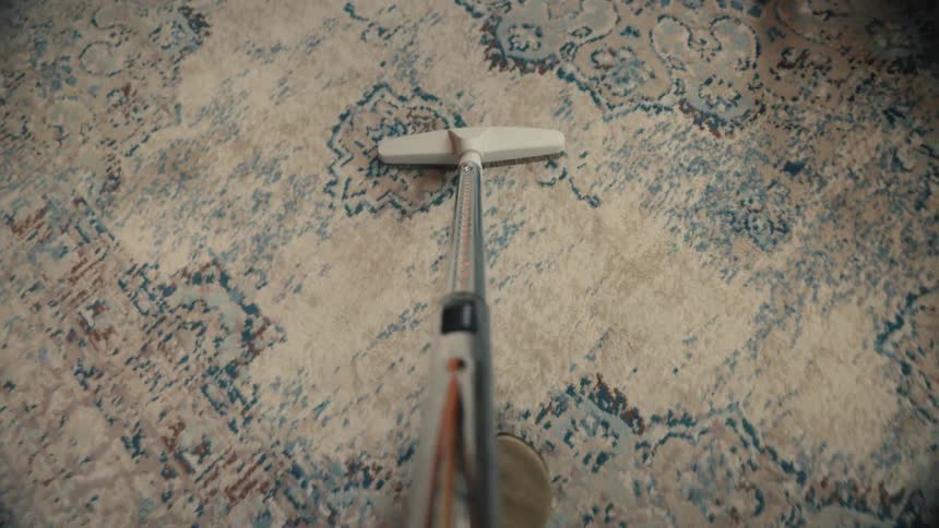A person is vacuuming the living room of their house