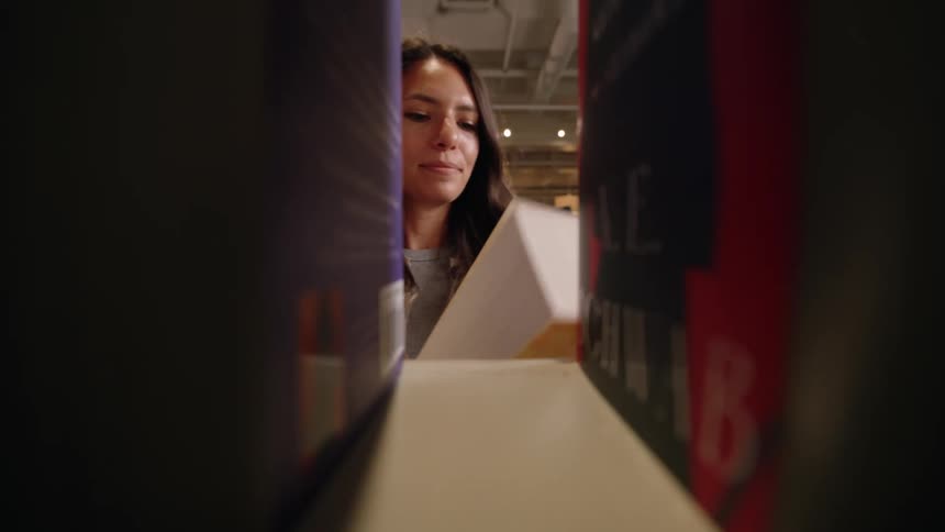 Woman grabbing book from shelf