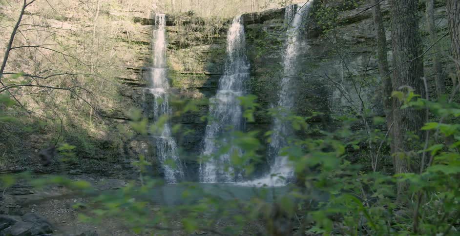 Water falls from the cliff into a ravine