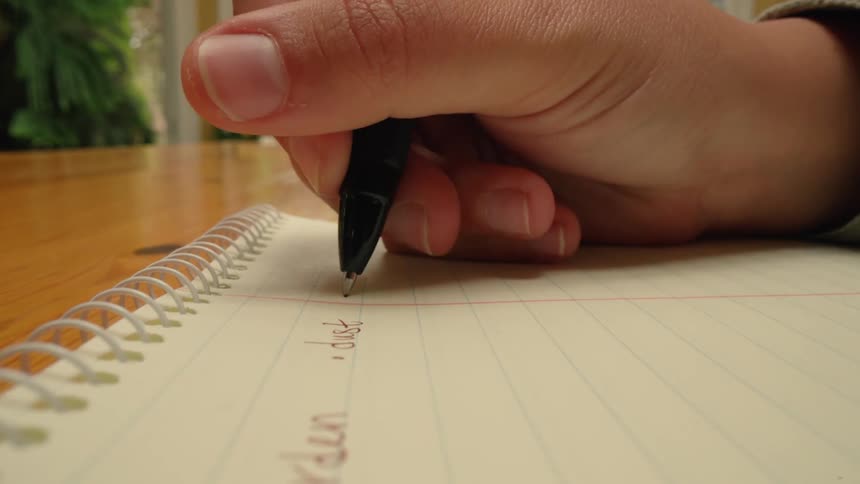Close up of a hand writing on a notepad