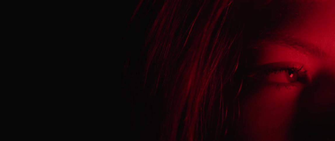 Girl's right eye and long hair in dark