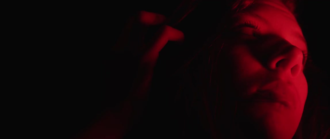 A view of someone's hand moving down something and the scene is very dark