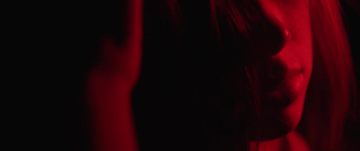A view of a person in the dark with some red lighting