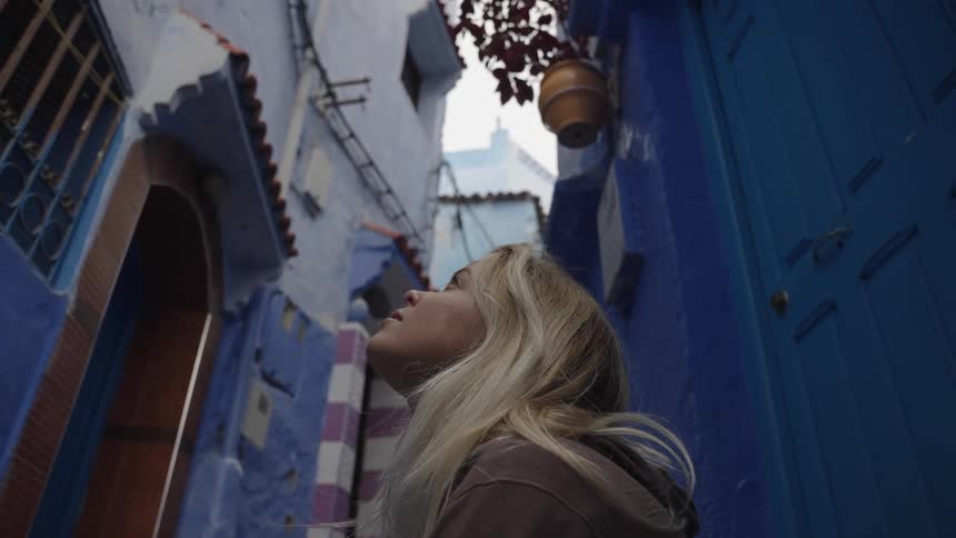 A woman is looking up in the alley