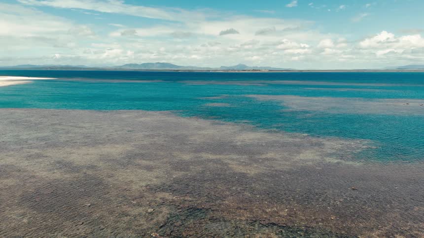 The water is calm with no big waves at a coastal area