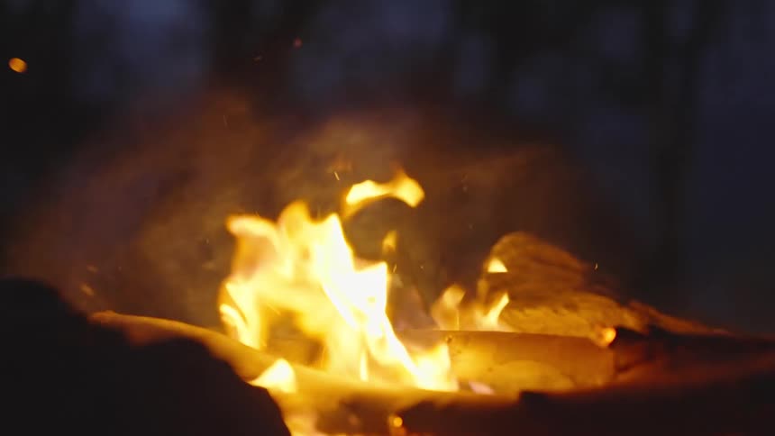 The campfire burns at night