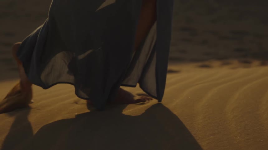 Closeup of a persons legs as they walk through a desert in daytime