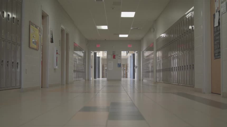 A lowangle shot of an empty school hallway lined with lockers creates a quiet symmetrical scene