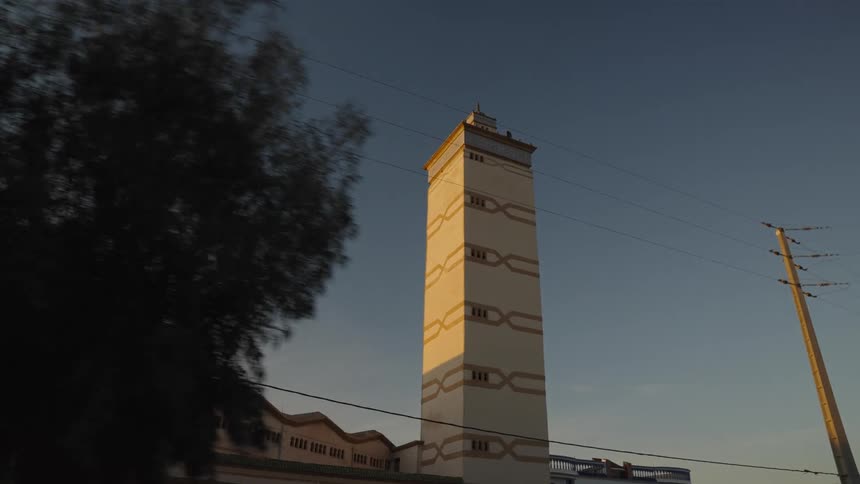 Moving view of a citys streets and a tower stands out against a dark sky