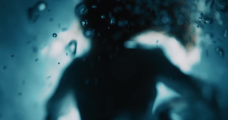Silhouette of a person among oxygen bubbles in the depths of the ocean