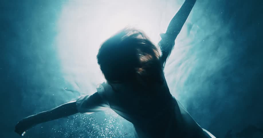 A woman is floating underwater