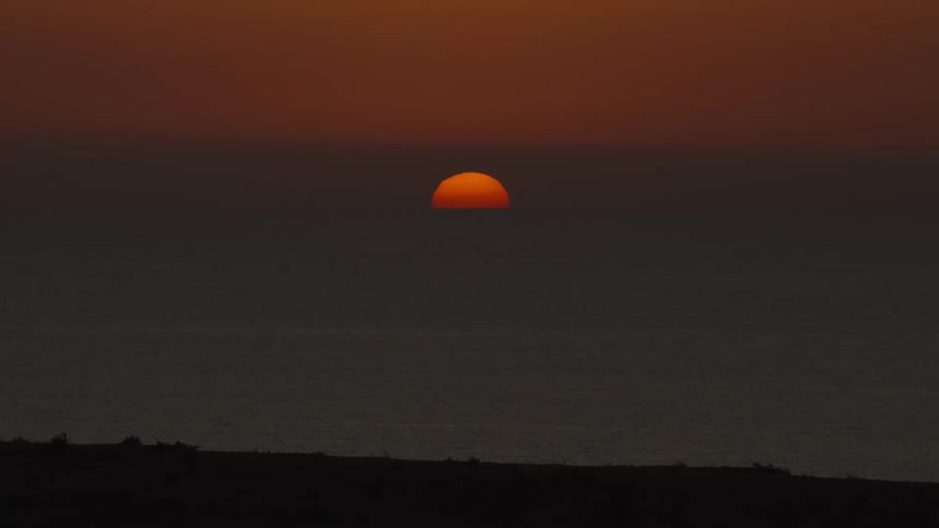 The sun is setting on the beach