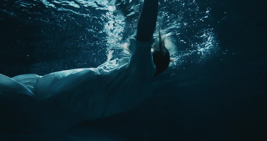 A woman is sinking in the water