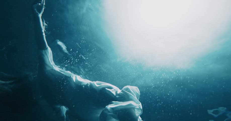 A spotlight shines on a woman floating in the water