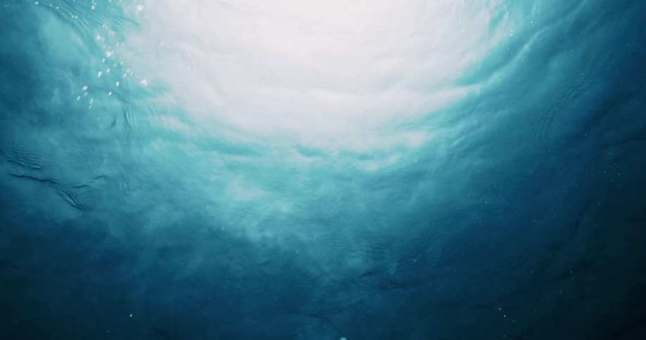View of the suns reflection underwater in the ocean and oxygen bubbles