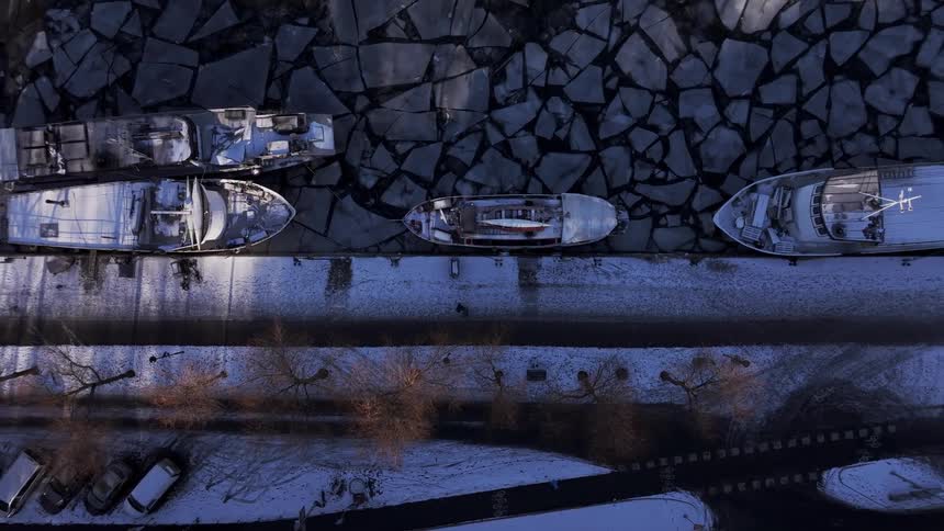 Boats are docked by the frozen shore