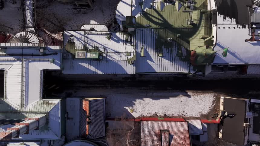 Aerial shot of an amusement park in a city covered in snow