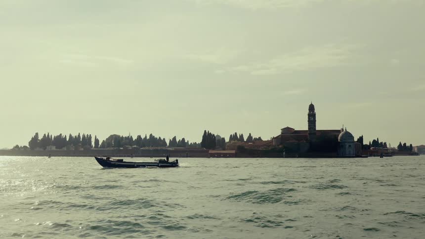 A boat travels in the water on a cloudy day