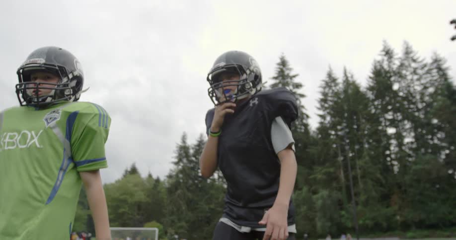A youth football team breaks huddle and sets for the next play