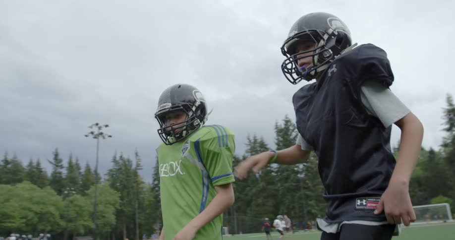 A group of football players huddled together on a field getting ready to play
