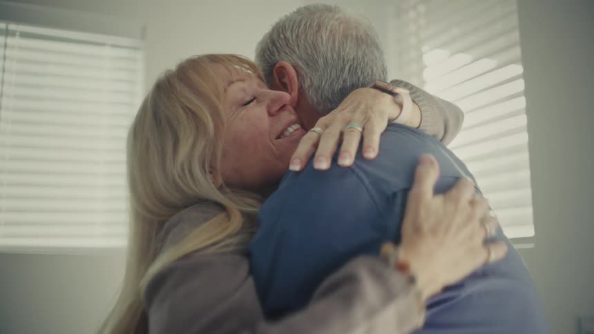 Man and woman hugs while standing indoor at daytime