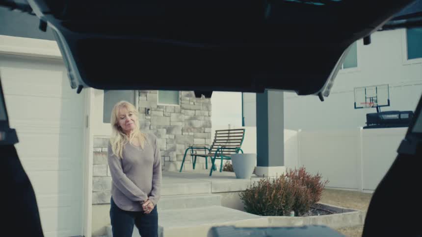 A man and a woman closing the fifth door of their suv