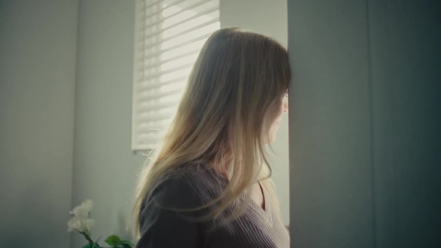 Woman closing the door of the house