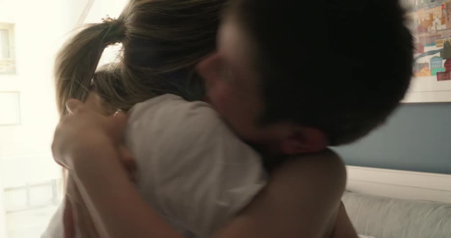 A mother hugs and kisses her son