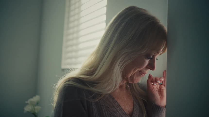 An older woman with a slight smile deep in thought