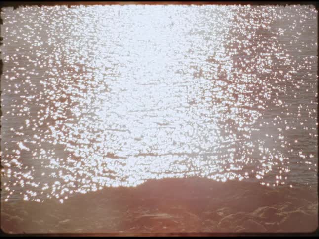Zoom in on a splash made by a fish in a lake at sunset