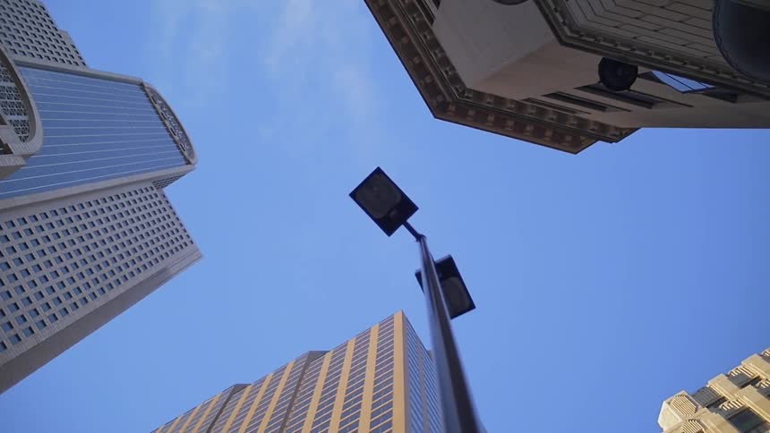 A street lamp and city buildings tower overhead