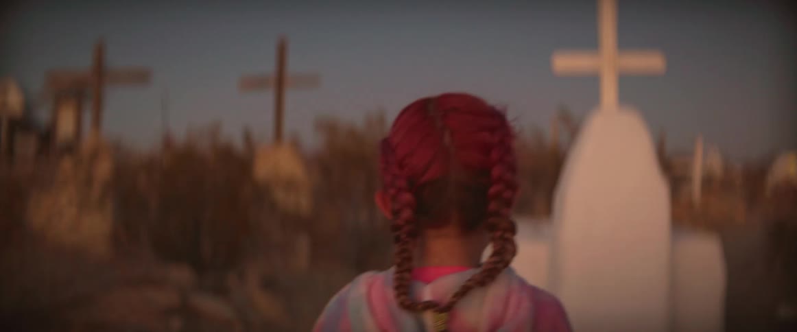 A little girl is walking through the graveyard