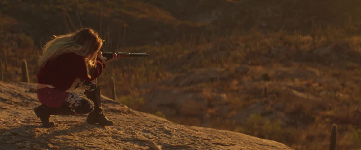 A footage of a lady aiming to shoot with the gun